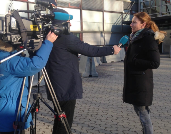 en kvinne blir intervjuet av nrk foran oslo politihus